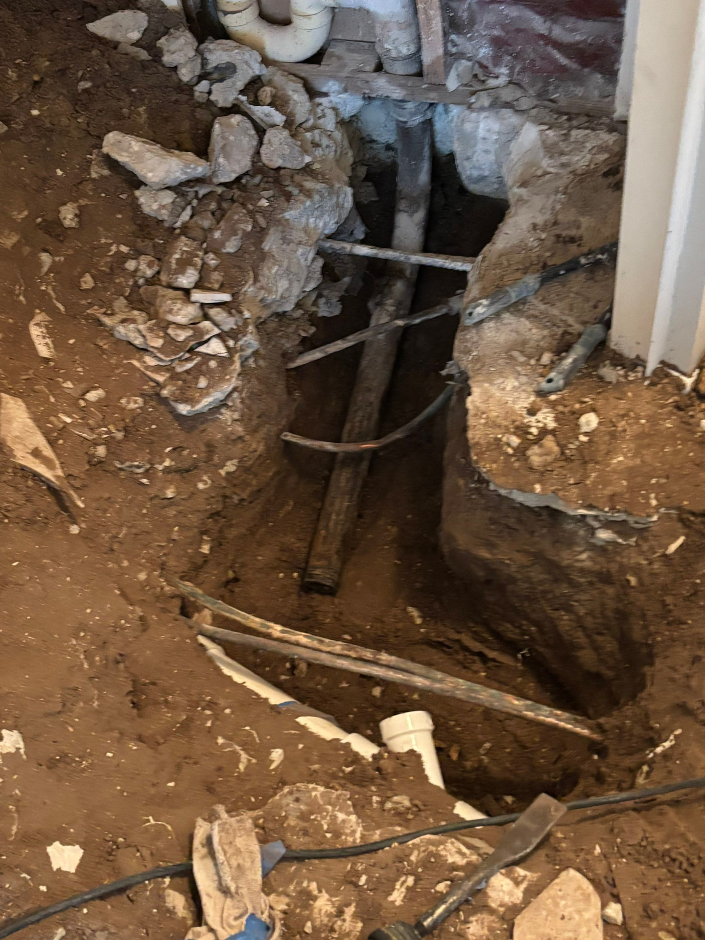 Copper water line exposed in an under-slab tunnel during a slab leak repair