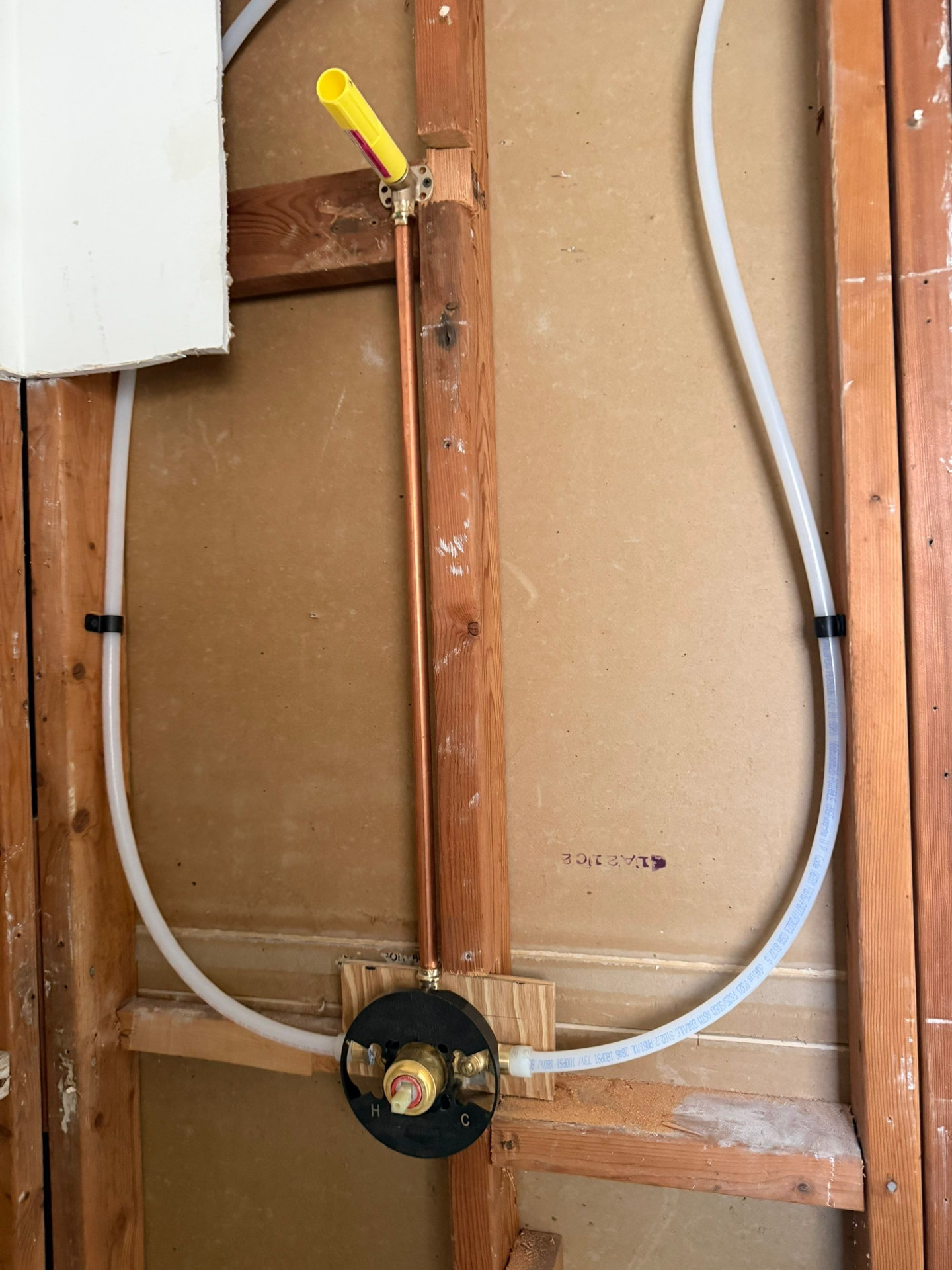 Shower mixing valve roughed in between studs with new PEX hot and cold lines and a copper shower riser