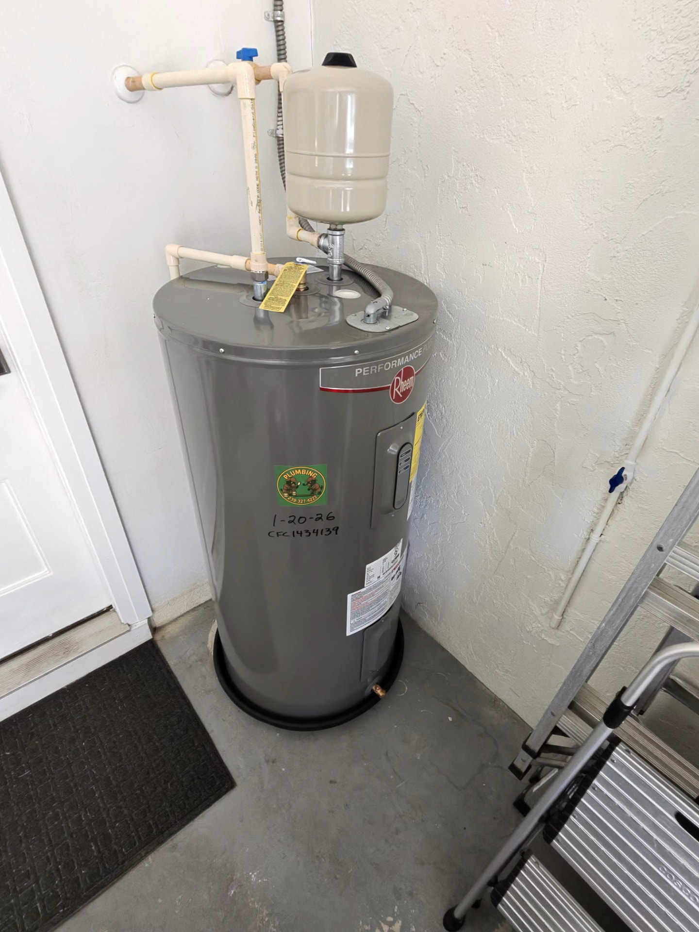 Completed Rheem water heater installation with thermal expansion tank, ball valve shutoff, and black drain pan