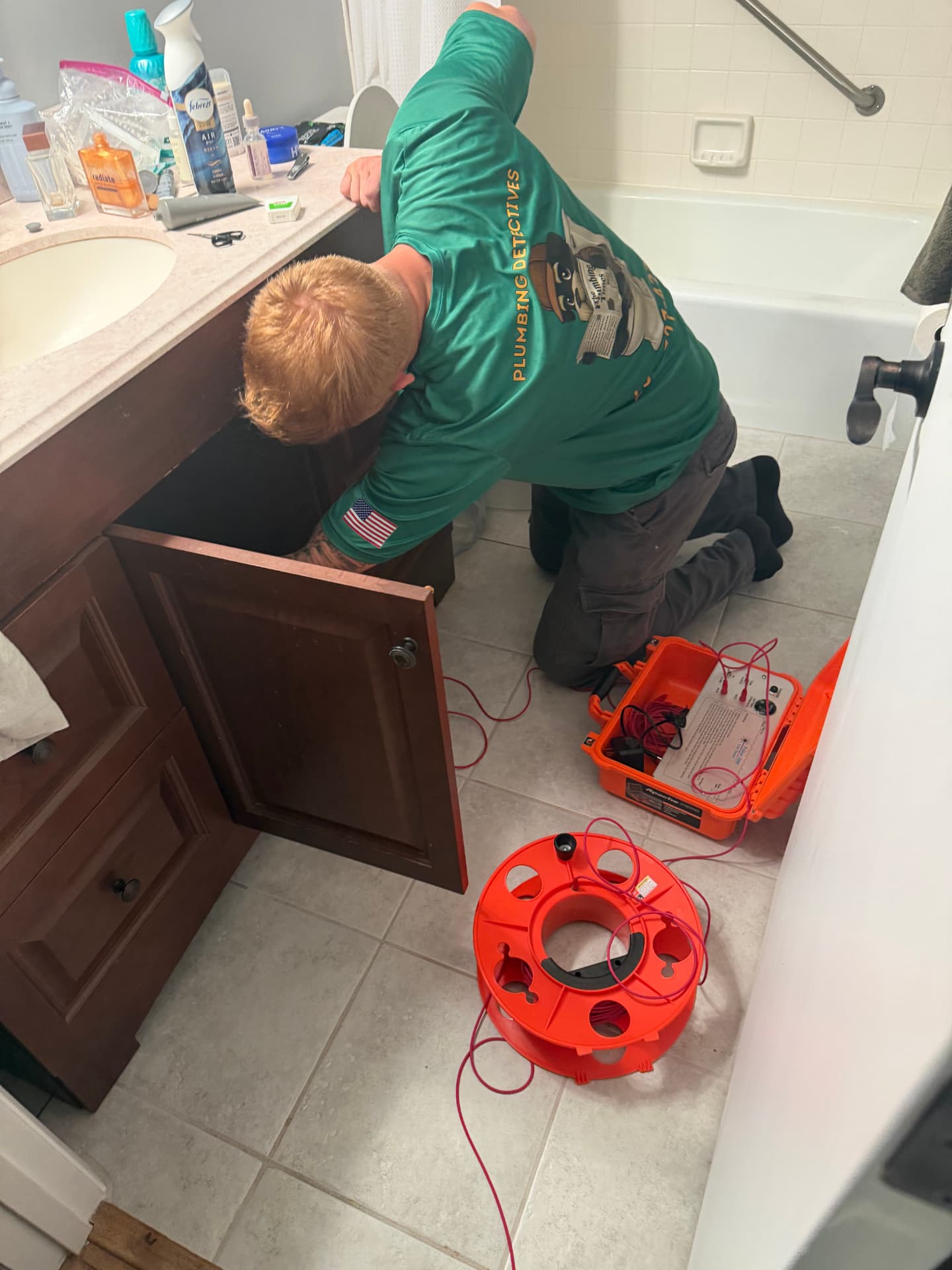 Technician clipping Pulsar 2000 alligator leads onto the affected water line during a slab leak line trace