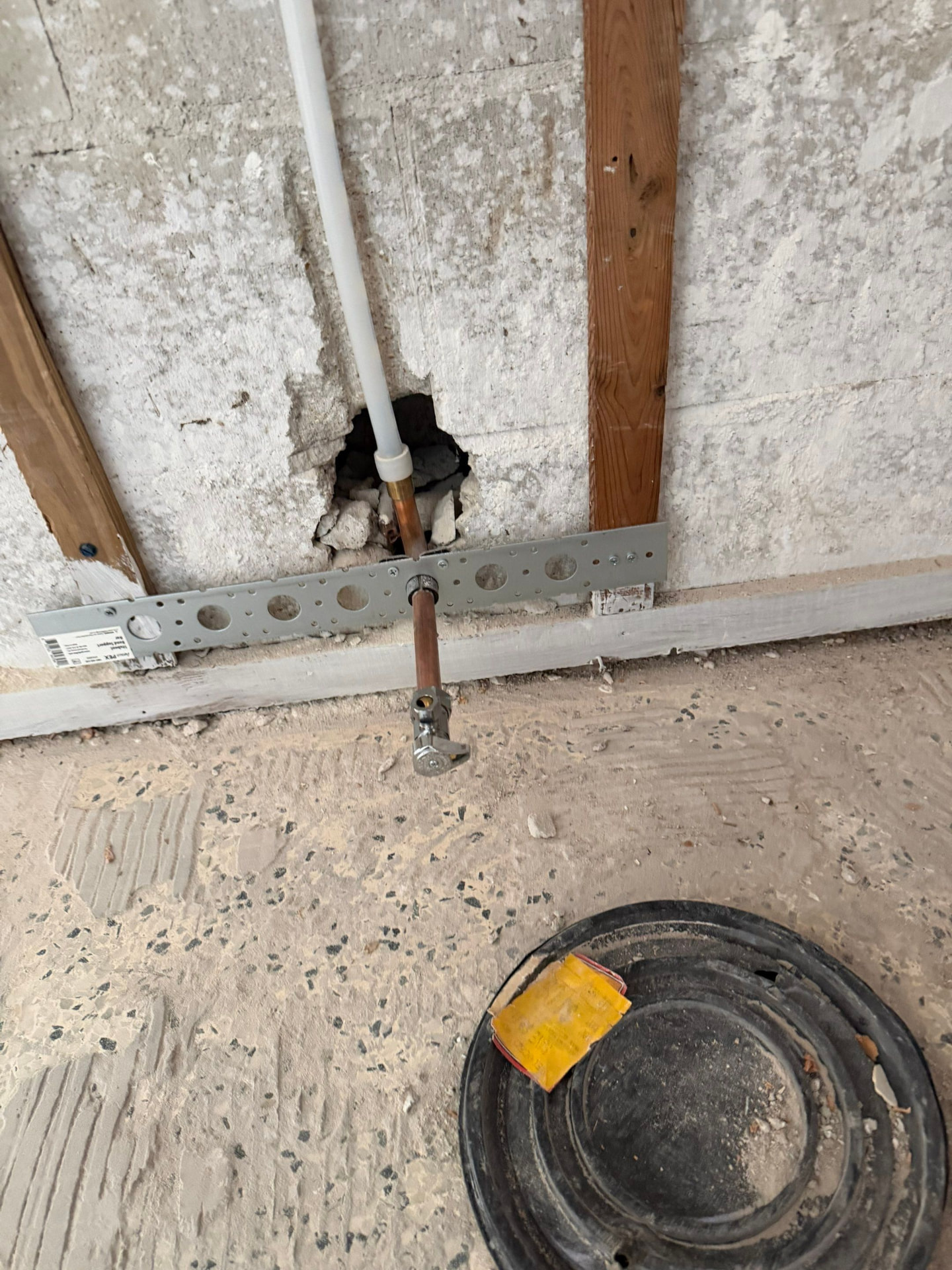 PEX line penetrating a block wall transitioning to copper stub-out with an angle stop valve