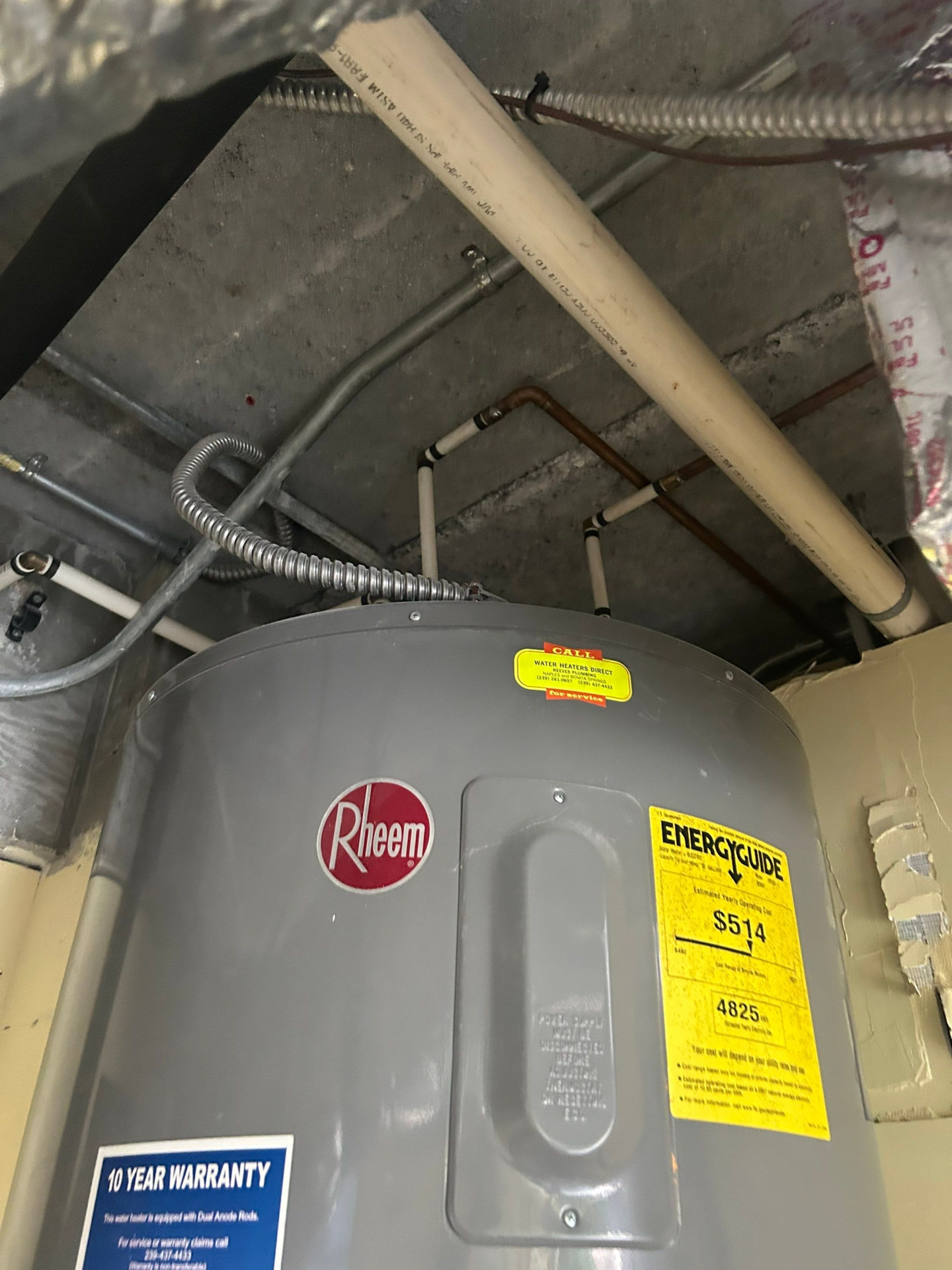 Rheem water heater with overhead CPVC and copper supply connections photographed before replacement
