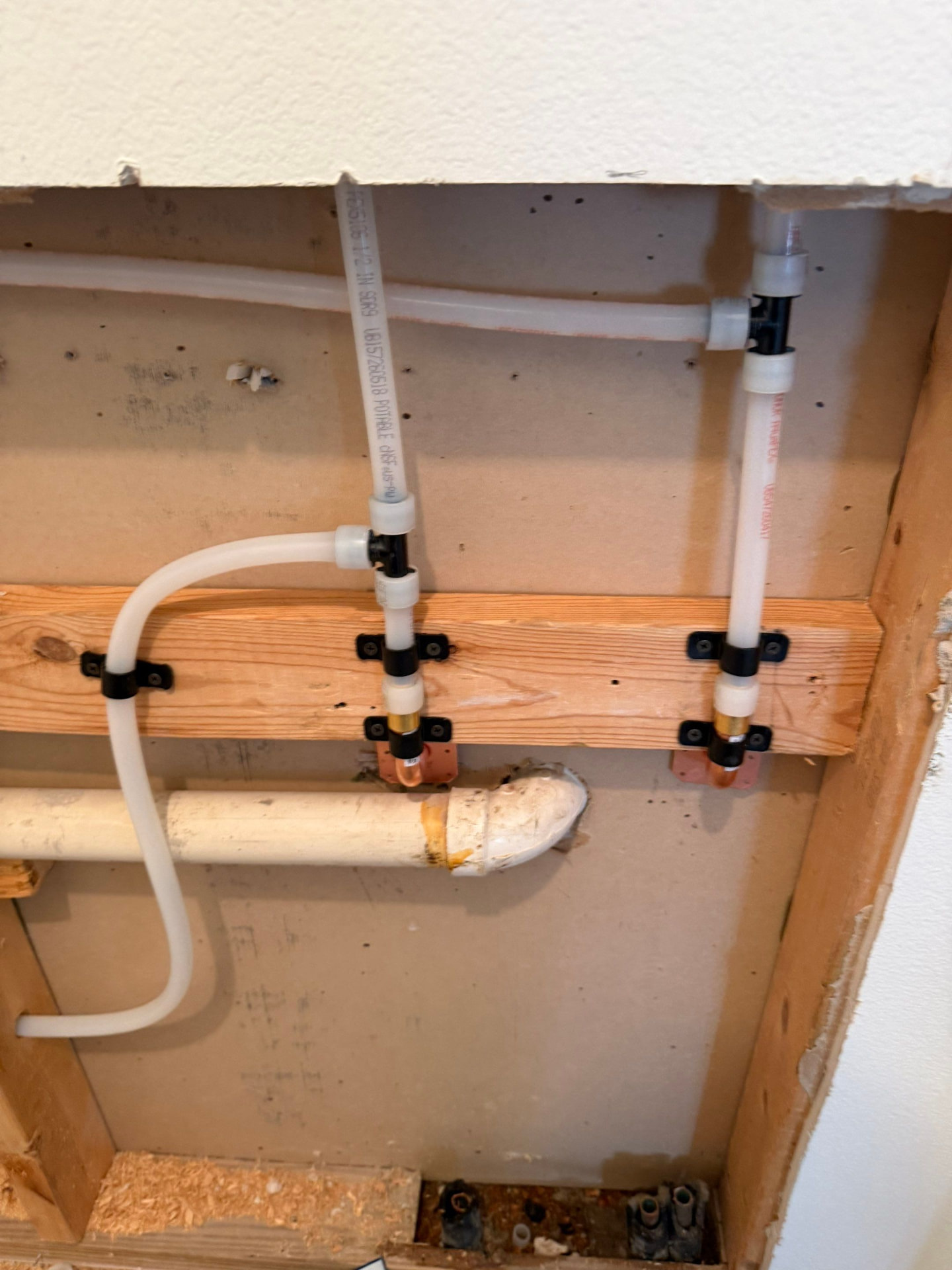 PEX supply lines clamped to wood blocking with copper drop-ear elbows set for fixture stub-outs