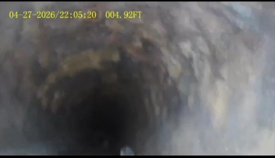 Sewer camera still at 4 feet showing heavy scale buildup narrowing a cast-iron line