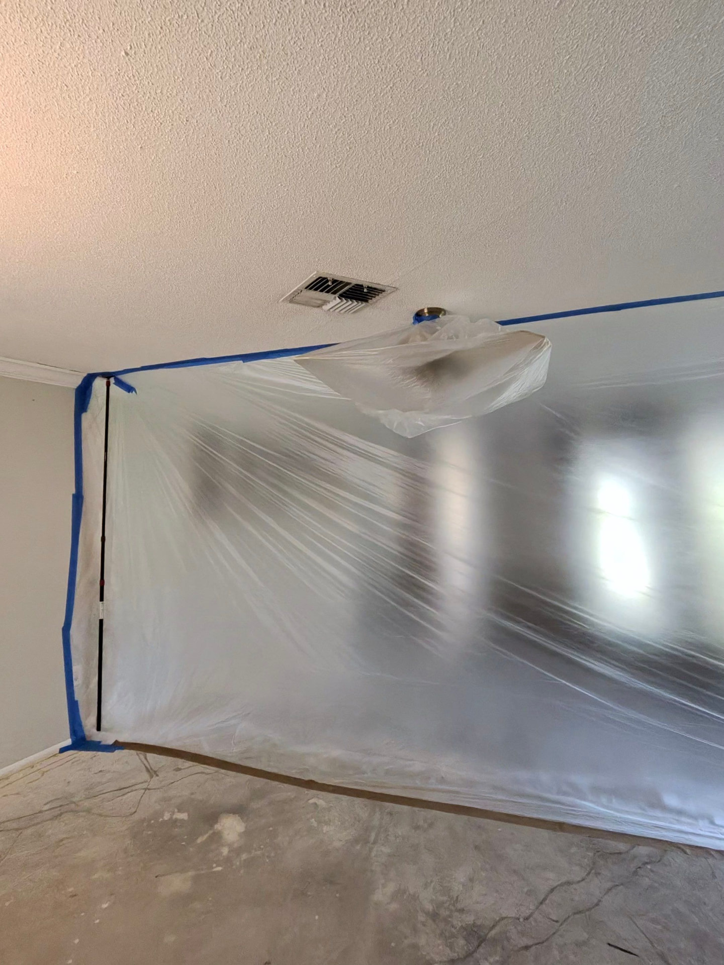 Plastic sheeting taped over the wall and ceiling to protect the work area
