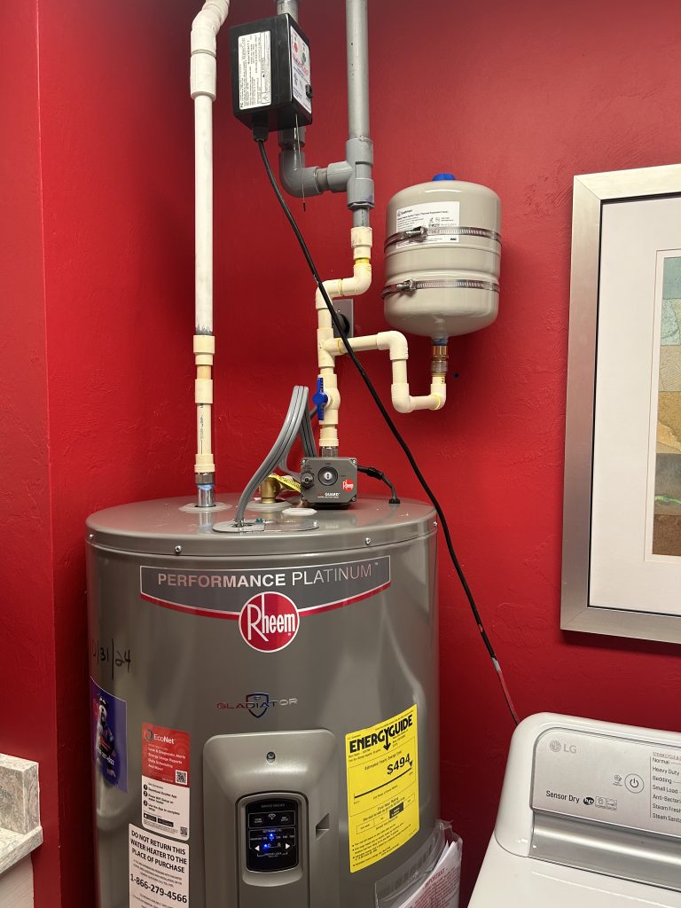 Performance Platinum water heater with red walls and adjacent laundry appliance.